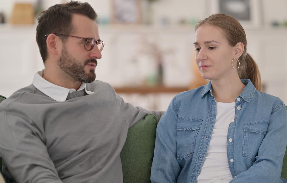 couple in serious discussion on sofa